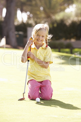 Young Girl Practising Golf On Putting On Green