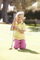 Young Girl Practising Golf On Putting On Green