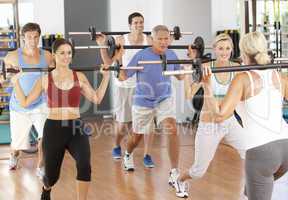Group Of People Lifting Weights In Gym