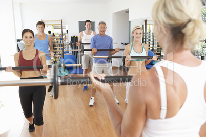 Group Of People Lifting Weights In Gym