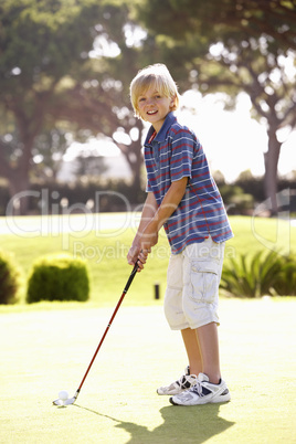 Young Boy Practising Golf On Putting On Green
