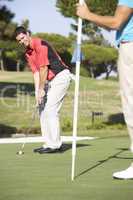 Male Golfer On Golf Course Putting On Green
