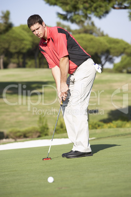 Male Golfer On Golf Course Putting On Green