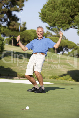 Senior Male Golfer On Golf Course Putting On Green