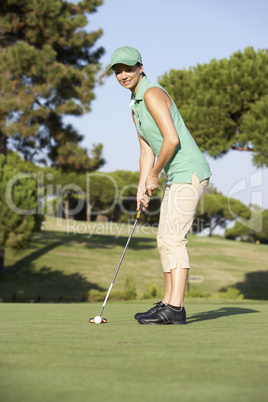 Female Golfer On Golf Course Putting On Green