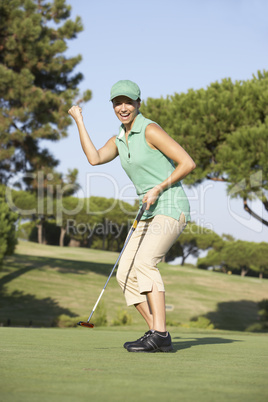 Female Golfer On Golf Course Putting On Green