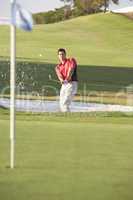 Male Golfer Playing Bunker Shot On Golf Course