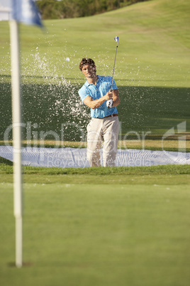 Male Golfer Playing Bunker Shot On Golf Course