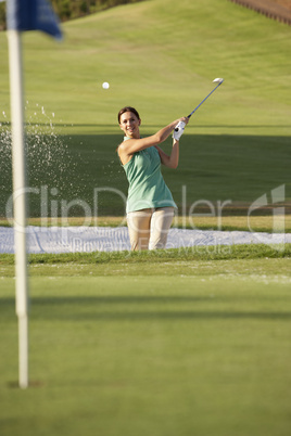 Male Golfer Playing Bunker Shot On Golf Course