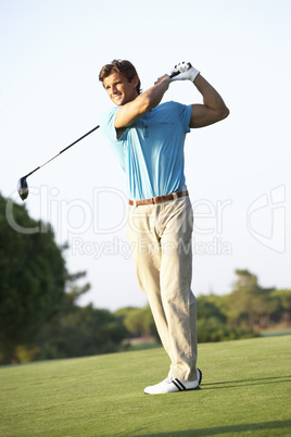 Male Golfer Teeing Off On Golf Course