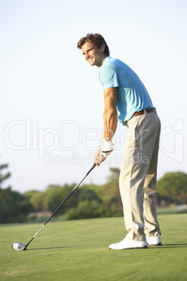 Male Golfer Teeing Off On Golf Course