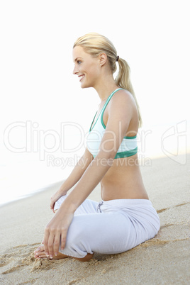 Young Woman In Fitness Clothing Resting After Exercise On Beach