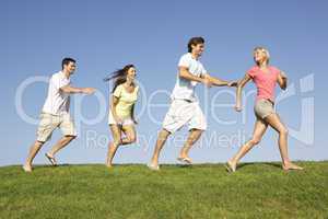 Young couples running through field