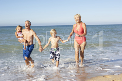 Grandparents With Grandchildren Enjoying Beach Holiday Together