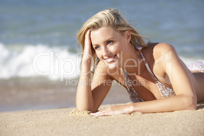 Young Woman Sunbathing On Beach
