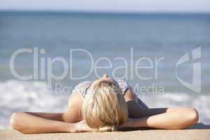 Young Woman Sunbathing On Beach