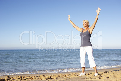 Senior Woman In Fitness Clothing Stretching On Beach