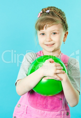 A girl playing with a green ball