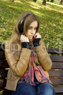 Attractive girl in park listens to music