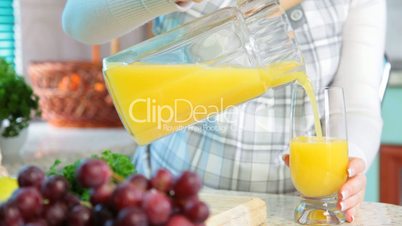 Pregnant woman pouring orange juice