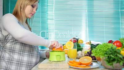 Pregnant woman squeezing orange