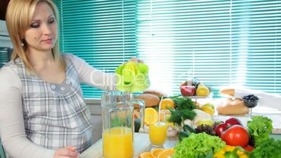 Pregnant woman preparing fresh orange juice