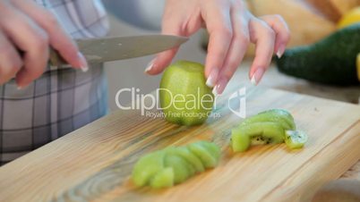 women hands slicing kiwi