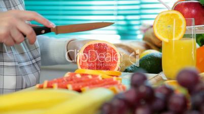 Woman hands cutting grapefruit