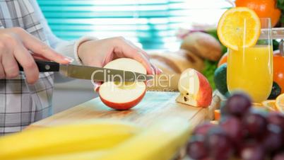 Women hands slicing red apple