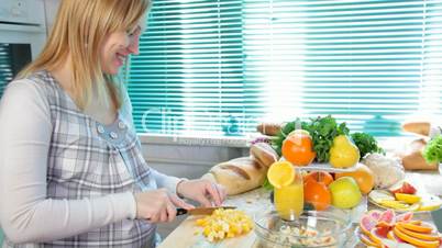 Pregnant woman cutting orange