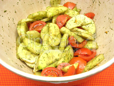 Gurken und Tomaten mit Salatdressing in Keramikschale