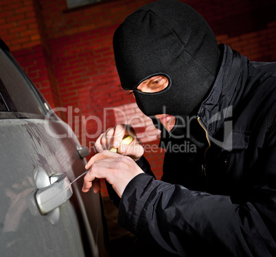 robber and the thief in a mask hijacks the car