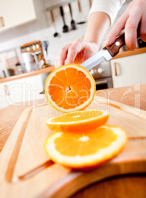 Woman's hands cutting orange