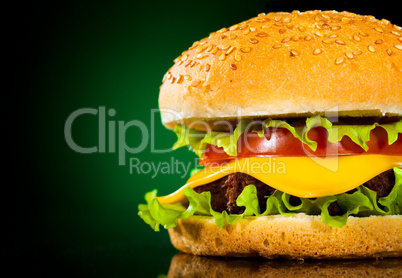 Tasty and appetizing hamburger on a darkly green background