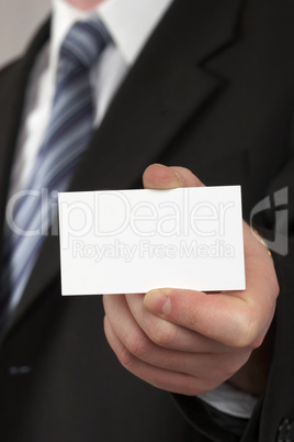 The businessman in a suit and a tie. Hand with a white card .