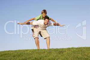 Young man with boy  playing in a field