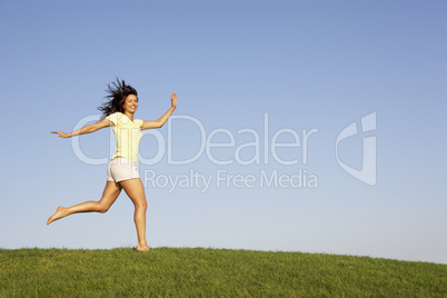 Young woman running through field