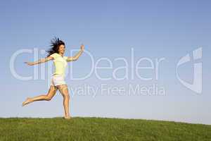 Young woman running through field