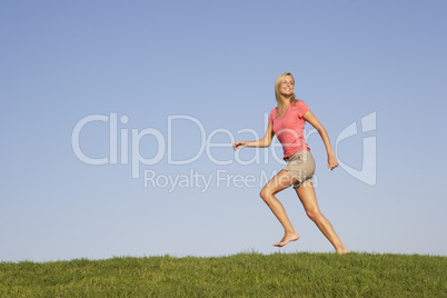 Young woman running through field