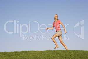 Young woman running through field