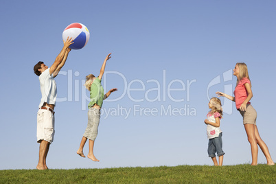 Young family, parents with children,  playing in a field