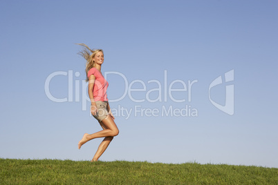 Young woman running through field