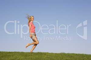 Young woman running through field