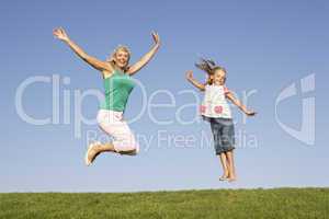 Senior woman with granddaughter jumping in air