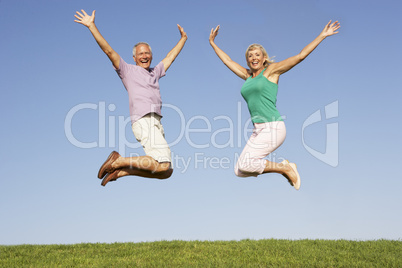 Senior couple jumping in air