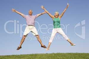 Senior couple jumping in air