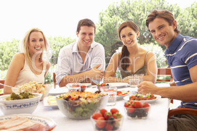 Two young couples eating outdoors