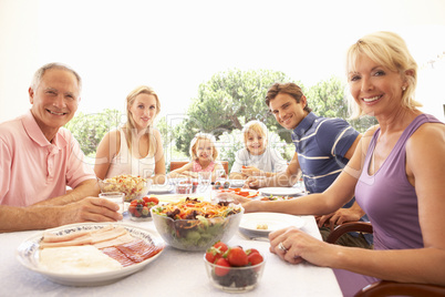 Extended family, parents, grandparents and children, eating outd