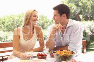 Young couple eating outdoors