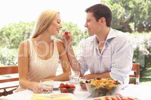 Young couple eating outdoors